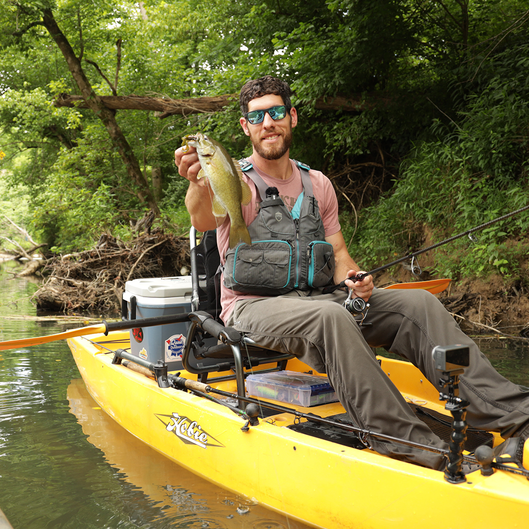 Chase W holding up a bass in a kayak
